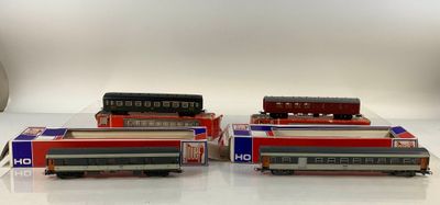 several model trains are lined up on a white surface