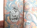 someone is holding a book with a picture of a coat of arms on it
