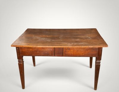 une vieille table en bois surmontée de deux tiroirs