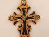 a close up of a cross on a white surface with a black and gold cross