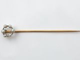 un gros plan d'une broche en métal ornée de perles
