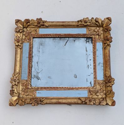 un miroir accroché au mur avec un cadre doré