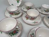 many cups and saucers sitting on a white table