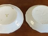 pair of white porcelain bowls sitting on top of a wooden table