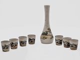 several shot glasses and a vase sitting on a white surface