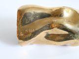 a gold sculpture of a woman ' s face on a white surface