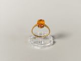 a close up of a gold ring with an orange stone on it