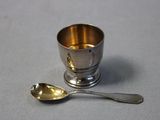 a silver cup and a spoon on a table