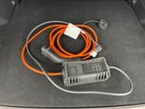 a car trunk with an orange cord and a charger