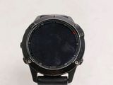 someone is holding a smart watch on their wrist on a white surface