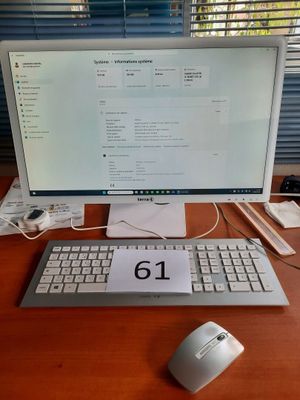 un ordinateur posé sur un bureau, avec une souris et un clavier