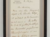 framed photograph of a handwritten letter in a black frame on a white wall