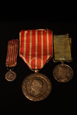 trois médailles et une médaille posée sur un fond noir