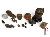 a small collection of bronze figurines on a white surface