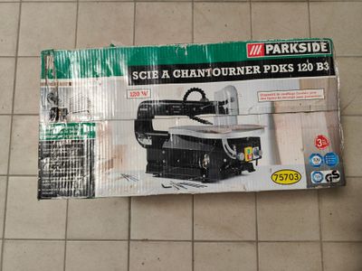 une boîte sur laquelle figure l'image d'une machine posée par terre