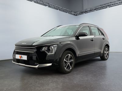 La voiture grise est garée dans une grande pièce aux murs blancs.