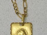 a gold necklace with a picture of an angel on it