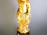 a gold statue of a boy holding a bowl on top of his head