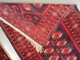 a red and blue rug with a fringe on it