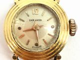 a close up of a gold wrist watch on a white surface