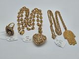 a collection of gold jewelry including a heart pendant, a necklace, and a ring
