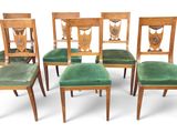 six chairs with green velvet upholstered seats and a wooden frame
