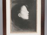 an old photo of a woman ' s face is shown in a wooden frame