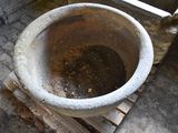 a large cement pot sitting on a pallet in the middle of a room