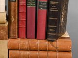several old books are stacked on top of each other on a table