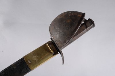 un couteau avec un manche en métal posé sur une surface blanche