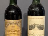 two bottles of wine sitting on top of a wooden table next to each other