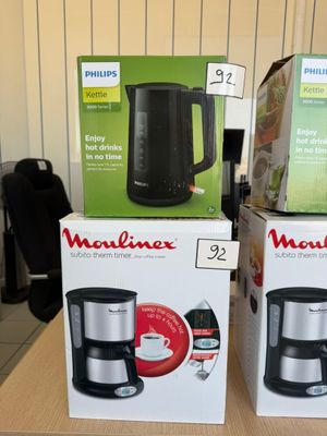 three boxes of coffee makers are on a table in a store