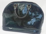 sac à main bleu et noir sur fond blanc