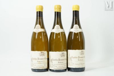 trois bouteilles de vin posées les unes à côté des autres sur une surface blanche