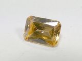 a close up of a yellow diamond on a white surface