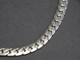 a close up of a silver chain on a black surface