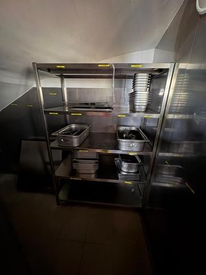 une cuisine équipée d'armoires en inox et de casseroles et poêles