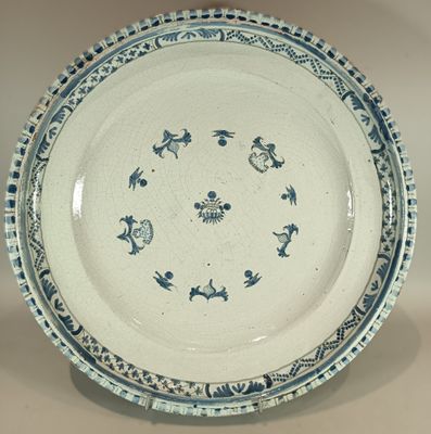 a blue and white plate on a stand on a table