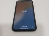 the back of a black iphone with a blue screen sitting on a table