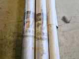 trois rouleaux de papier d'emballage posés par terre à côté d'une paire de ciseaux