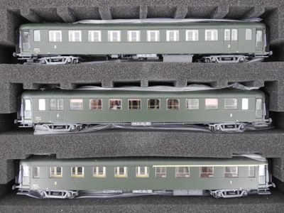 trois trains miniatures exposés dans une vitrine