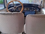 two seats in the back of a bus with a steering wheel