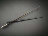 a metal stick with a long handle on a table