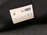 the back of a black jacket with a white label on it