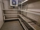 a small room with a lot of shelves and a ceiling fan