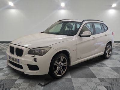 la bmw x1 est garée dans une grande pièce au sol en damier