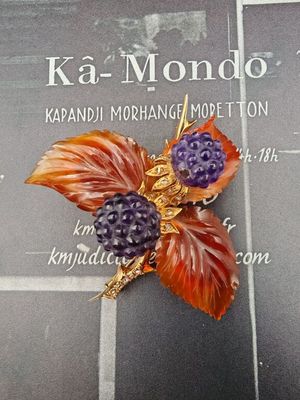 une photo d'une broche ornée d'une baie violette