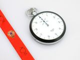une montre de poche en argent entourée d'un ruban rouge