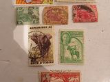 several different types of stamps on a table with a shadow of a person