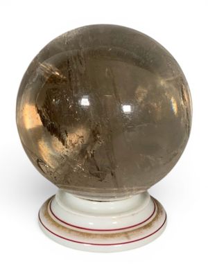 a crystal ball sitting on a pedestal on a white surface